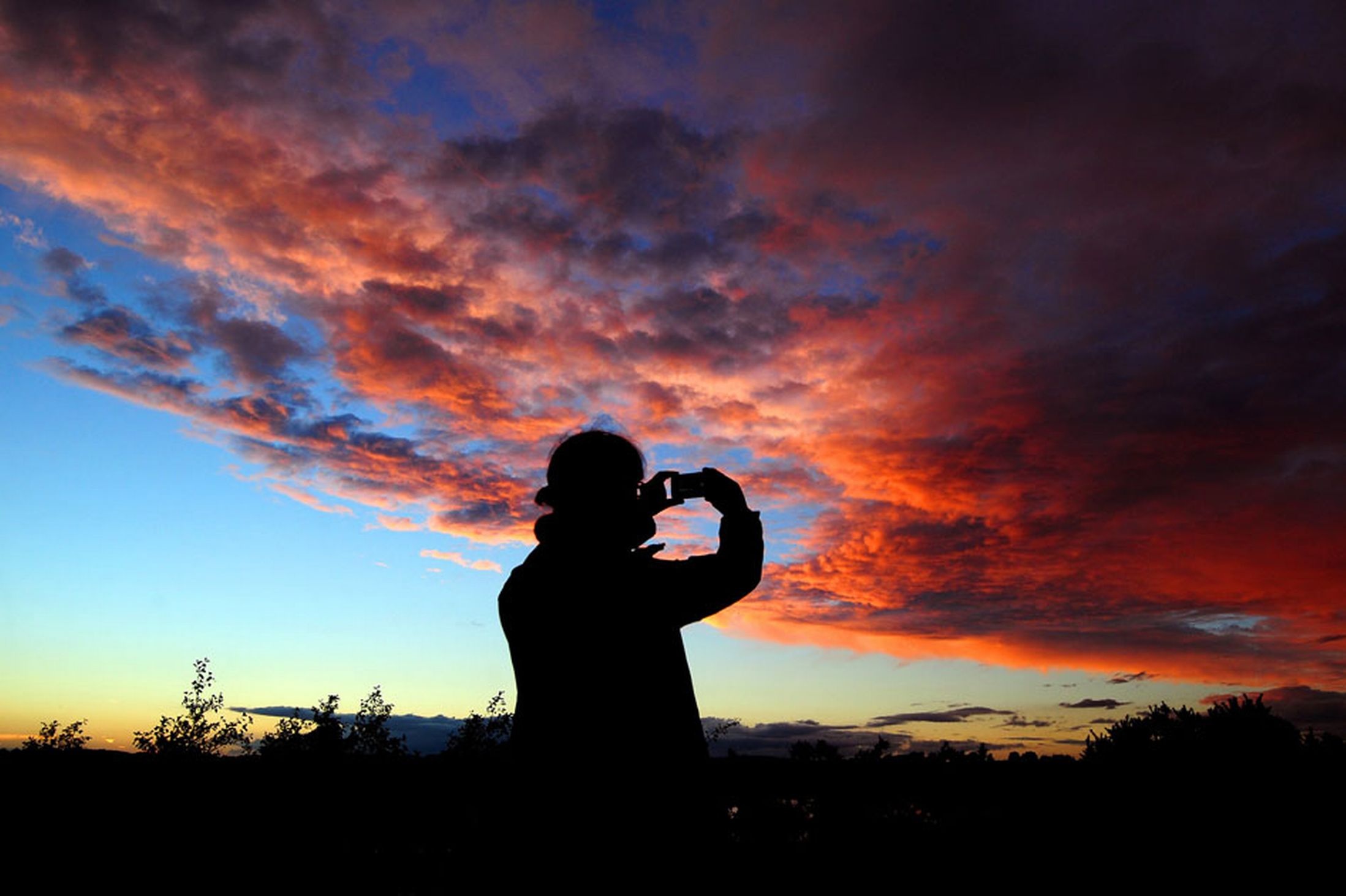 A-person-uses-a-phone-to-capture-a-sunset-sky-in-South-Derbyshire-19t-October-2641176