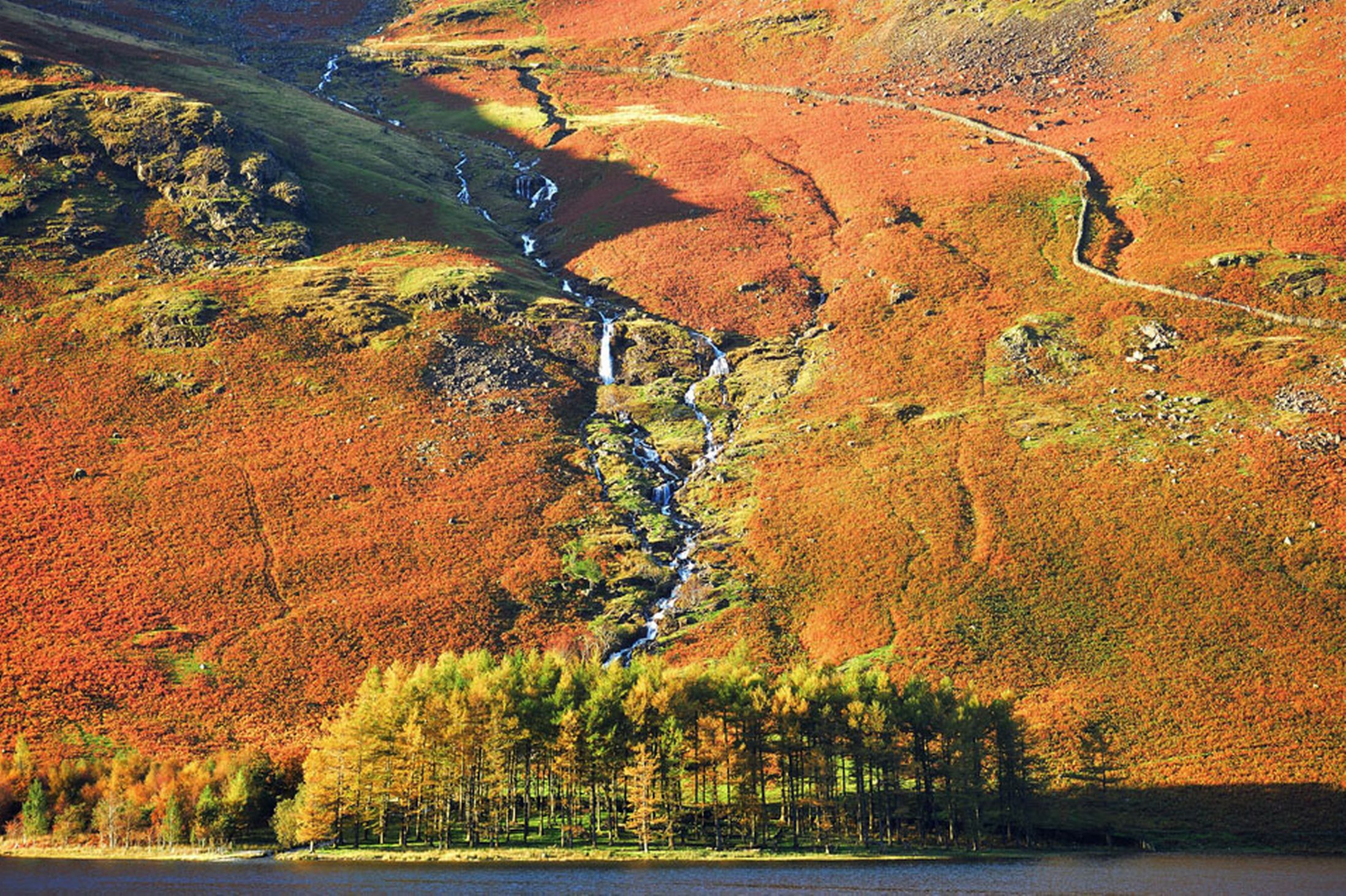 A-waterfall-flows-into-lake-Buttermere-in-Cumbria-24th-October-2641165