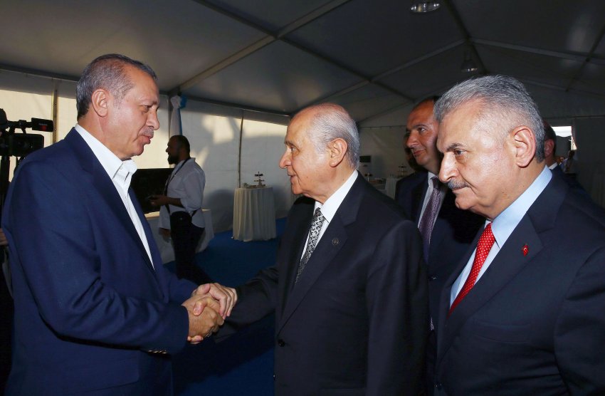 This handout picture taken and released by the Turkey's Presidential Press Service on August 7, 2016 at Yenikapi district of Istanbul shows Turkish President Recep Tayyip Erdogan (L) shaking hands with the Nationalist Movement Party (MHP) leader Devlet Bahceli (2L) as Turkish Prime Minister Binali Yildirim (R) stands before attending a rally held to protest against the July 15 failed coup. Hundreds of thousands of people gathered in Istanbul today for a pro-democracy rally organised by the ruling party, bringing to an end three weeks of demonstrations in support of President Recep Tayyip Erdogan after last month's failed coup. / AFP PHOTO / TURKISH PRESIDENTIAL PRESS OFFICE / STR / RESTRICTED TO EDITORIAL USE - MANDATORY CREDIT "AFP PHOTO / TURKEY'S PRESIDENTIAL PRESS SERVICE " - NO MARKETING - NO ADVERTISING CAMPAIGNS - DISTRIBUTED AS A SERVICE TO CLIENTS